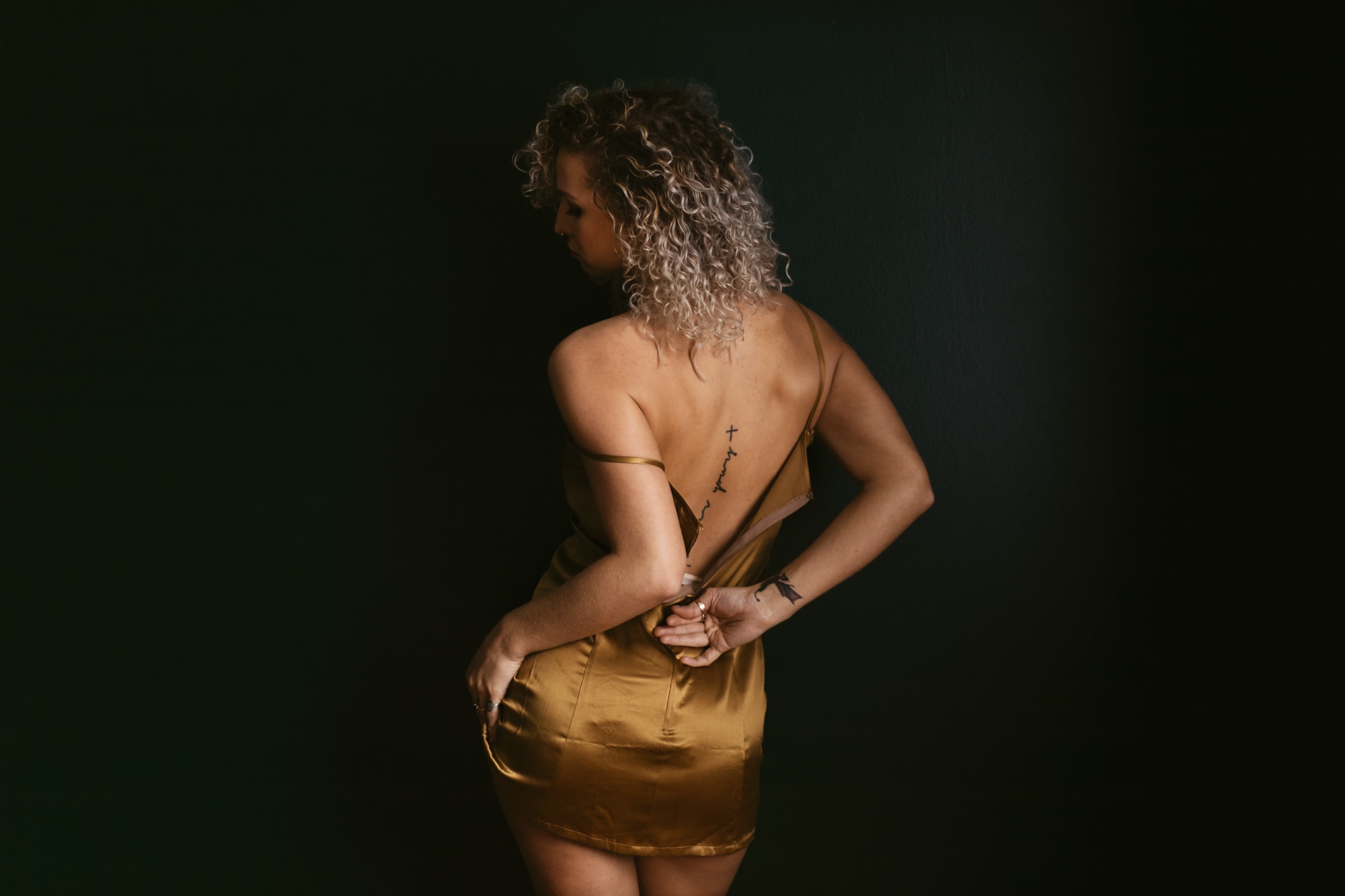 woman unzipping cocktail dress during a boudoir photography session in Nashville Tennessee